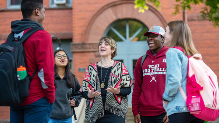 VCSU students and director for diversity and inclusion talking on campus lawn